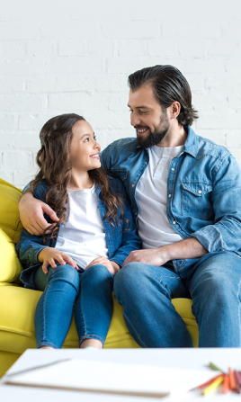 Padre e hija convesando en el sofá