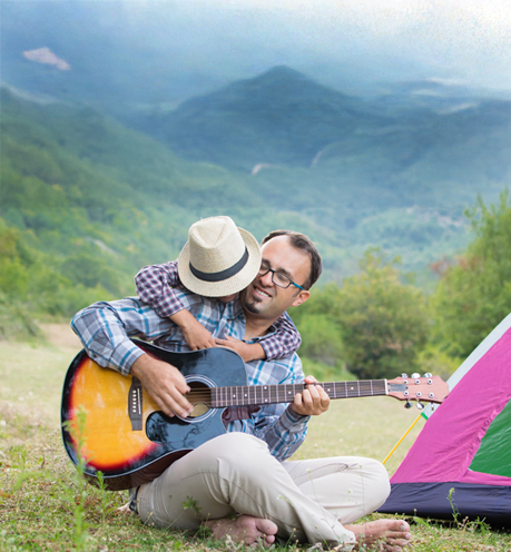 Papa e hijo tocando la guitarra en el campamento