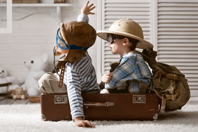 Niños jugando a viajar en avión dentro de una maleta