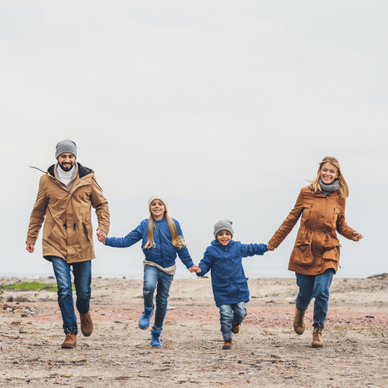 Familia corriendo de la mano en la nieve.