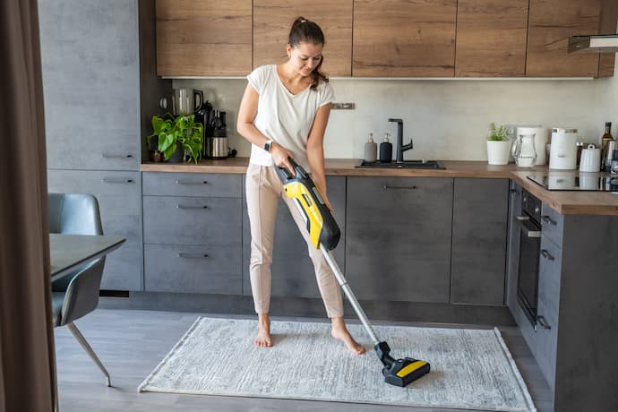 mujer limpiando su hogar con aspiradora