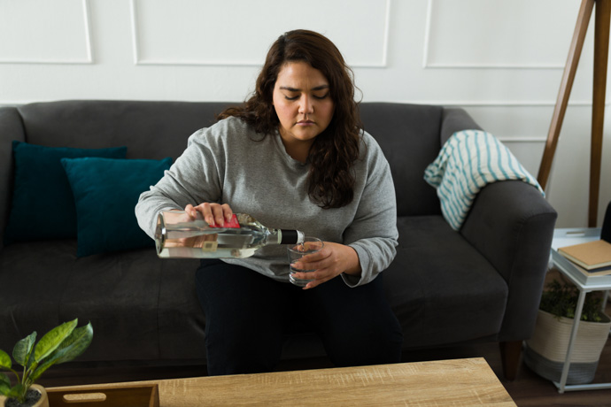mujer sirviendo un vaso de alcohol