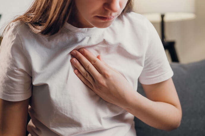 Mujer joven apretándose el pecho por dolor