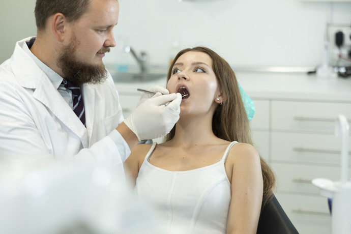 Dentista revisa puntos blancos en las encías