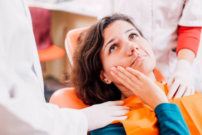 Imagen de mujer en el dentista porque no sabe qué es bueno para el dolor de muelas.