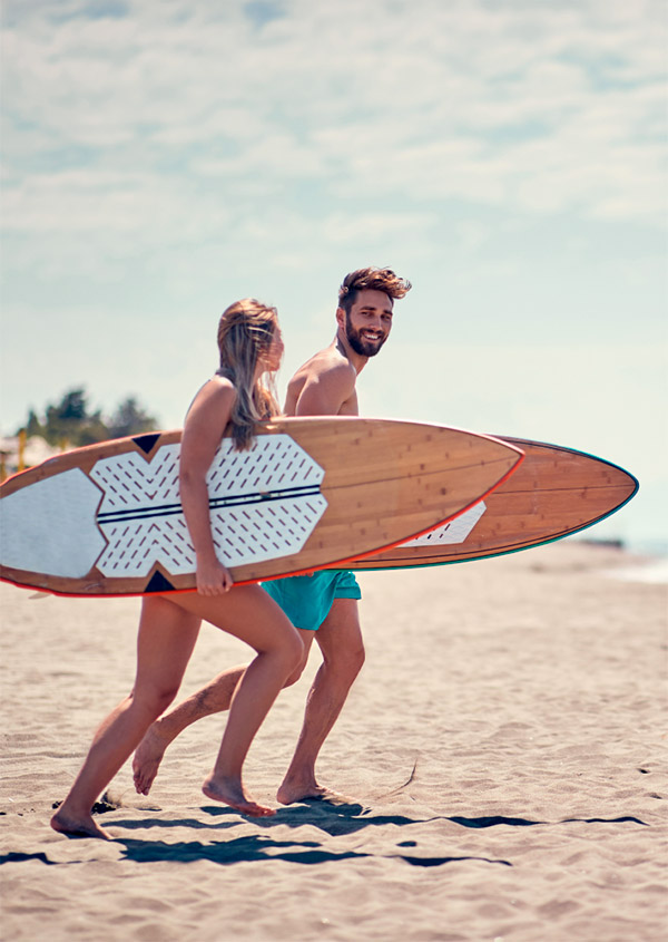 Dos jóvenes en la playa con sus tablas de surf.