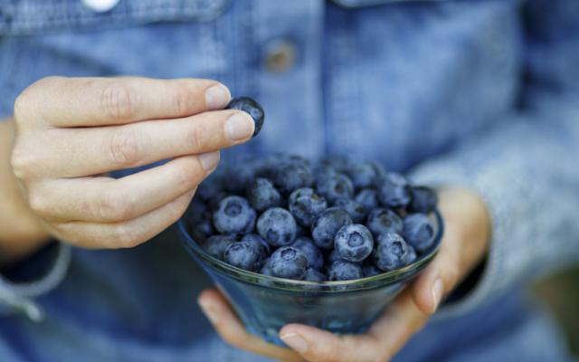 Persona comiendo arándanos