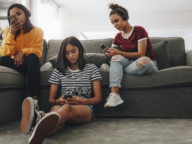 Grupo de adolescentes usando teléfono para ver memes