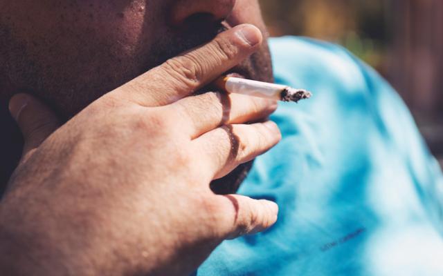 hombre con sobrepeso fumando